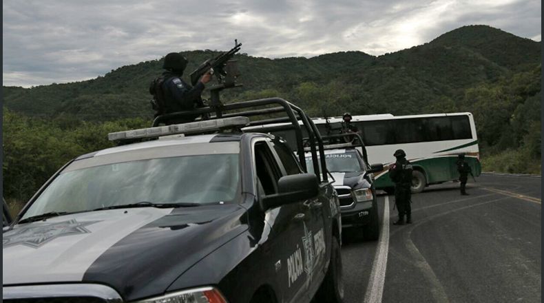 La policía vigila un autobús donde viajaban estudiantes de la Escuela de Ayotzinapa, ayer, miércoles 13 de septiembre de 2017, en la autopista Chilpancingo-Tixtla, en el estado de Guerrero (México). Alumnos de la Escuela mexicana de Ayotzinapa, a la que asistían 43 jóvenes desaparecidos en 2014, retuvieron a 4 policías, cuya liberación negocian con el Gobierno del estado de Guerrero (sur) a cambio de la de 10 estudiantes detenidos por robo de combustible, dijeron hoy fuentes oficiales. EFE/José Luis de la Cruz