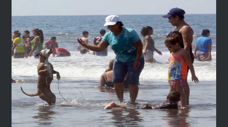 Karla Bermudez juega con su perrita Lasie en playa El Majahual,La Libertad durante el último día de las vacaciones de Semana Santa.Ericka Chávez