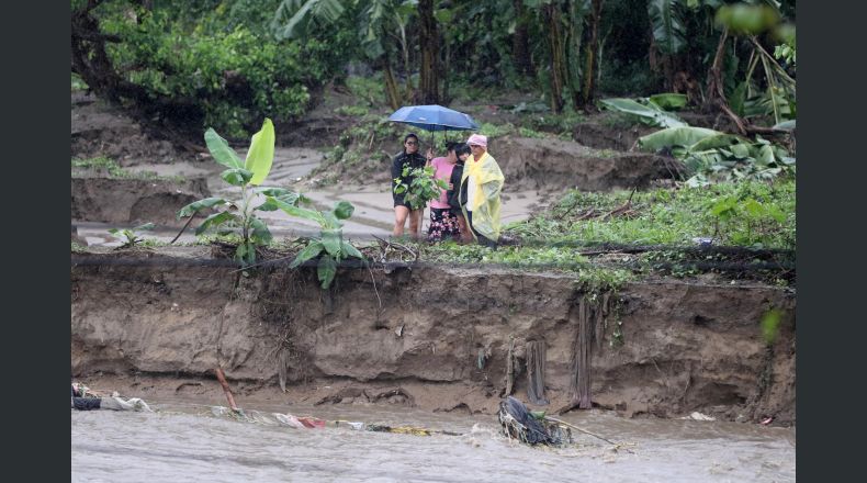 Personas esperan para ser evacuadas debido a la crecida de un río por el paso de la tormenta Sara, este sábado, en el sector de la aldea Tikamaya, en la ciudad de San Pedro Sula (Honduras). la Secretaría de Gestión de Riesgos y Contingencias Nacionales (Copeco) sumó este sábado a un sexto departamento en alerta roja (evacuación obligatoria) ante las intensas lluvias que sigue causando una estacionaria tormenta tropical Sara, en el Caribe, con miles de personas afectadas. EFE/ Gustavo Amador