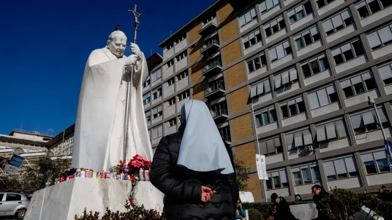 Una estatua del difunto Papa Juan Pablo II a las puertas del Hospital Gemelli, donde el Papa Francisco está recibiendo tratamiento médico. REUTERS