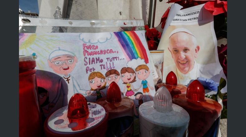 Un dibujo y una imagen del papa Francisco se colocan bajo la estatua del papa Juan Pablo II en el exterior del Hospital Agostino Gemelli, donde el papa Francisco se encuentra actualmente hospitalizado, en Roma (Italia), el 23 de febrero de 2025. El papa continúa con sus tratamientos por una neumonía bilateral después de ser ingresado en el hospital el 14 de febrero debido a una infección del tracto respiratorio. (Papa, Italia, Roma) EFE/EPA/GIUSEPPE LAMI