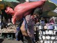 Un hombre carga un saco de maíz en el mercado de Comayaguela, en las afueras de Tegucigalpa, días después de las elecciones generales en Honduras, el 30 de noviembre de 2021. Foto: AP.