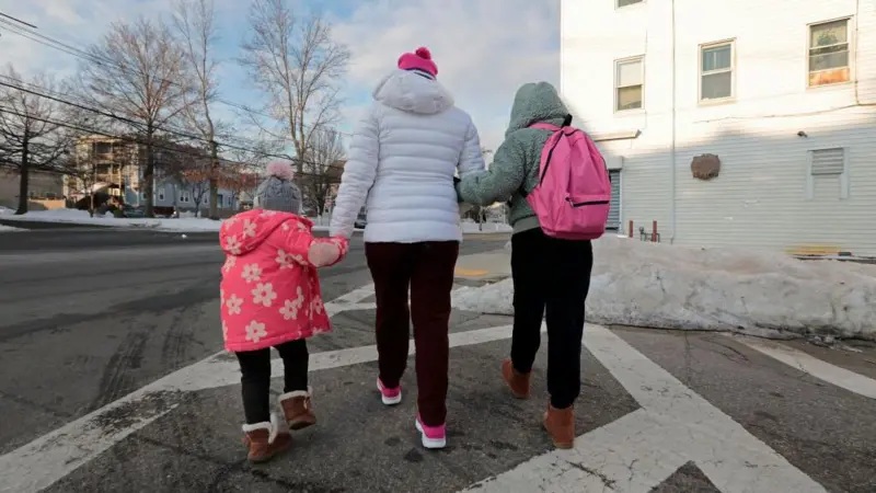 Una madre indocumentada camina con sus hijas.